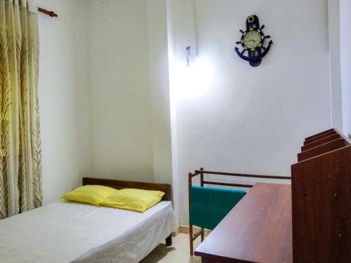 um quarto com uma cama e um relógio na parede em Villa Charumathi em Matara