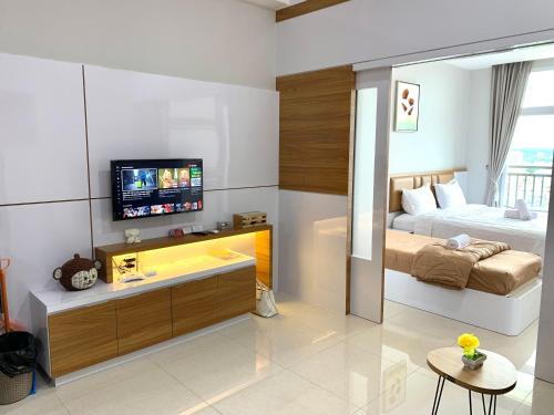 a living room with a bed and a tv in it at Family room at Apartemen Formosa Residence Nagoya Batam by Wiwi in Nagoya