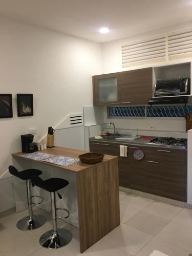 a kitchen with a counter and two bar stools at Cabañas Annapurna in Taganga