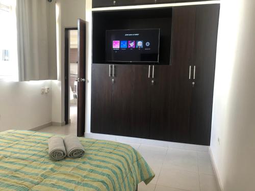 a bedroom with a bed with a flat screen tv at Cabañas Annapurna in Taganga