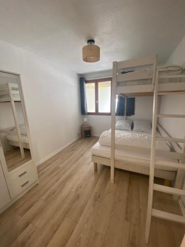 um quarto com 2 beliches e piso em madeira em Appartement au pied des pistes et commerces - 5 personnes em Modane