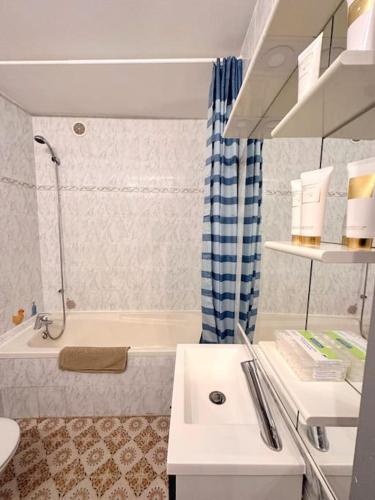 une salle de bain avec une baignoire, un lavabo et des toilettes dans l'établissement Appartement bord de mer, à La Grande Motte