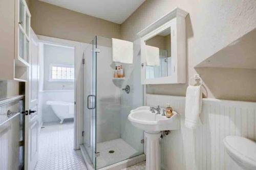 a white bathroom with a sink and a shower at Golf course view vacation home in The Woodlands
