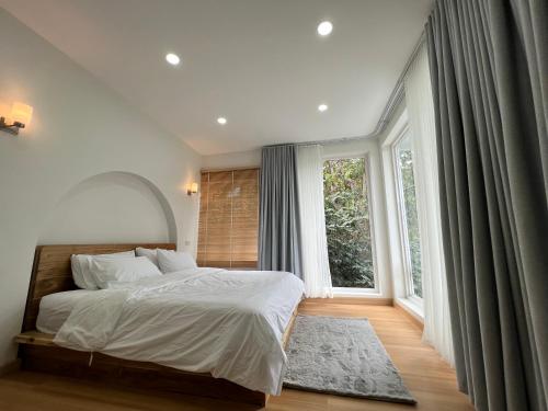 a bedroom with a bed and a large window at Arabica Lodge (อาราบิก้า ลอดจ์) in Ban Huai Khai