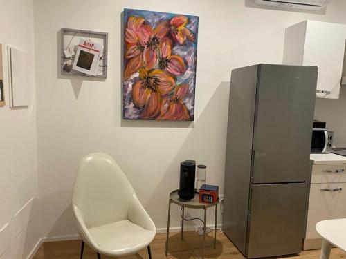 una cocina con una silla y una pintura en la pared en CASA NOVA Luxury Apartment Suite Fichi d'India, en Nova Milanese