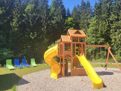 a small playground with a slide and chairs at HORSKÝ PENZION U SPLAVU in Josefuv dul