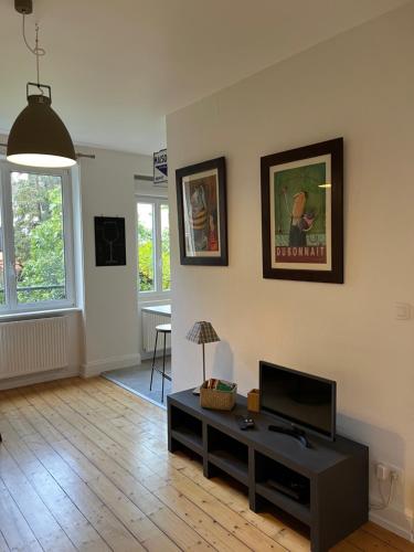 a living room with a tv and a table at les Gîtes de la limonaderie in Strasbourg