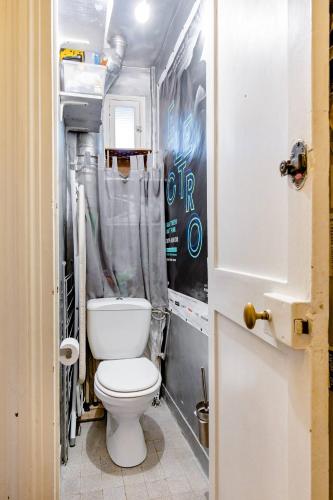 une salle de bain avec toilettes et rideau de douche dans l'établissement Bel appartement Ile saint Louis, Paris centre, à Paris