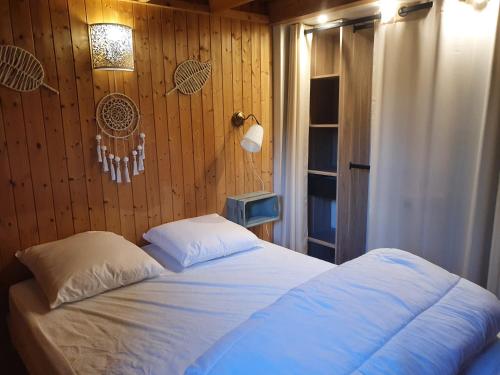 - une chambre avec un lit et un mur en bois dans l'établissement Chalet à Cabourg, à Cabourg