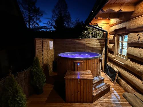 a hot tub in a backyard at night at Wierchowe Domki z jacuzzi in Kościelisko