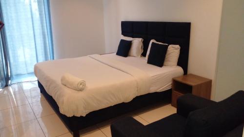 a bedroom with a large bed and a chair at Embassy garden by Eric in Accra