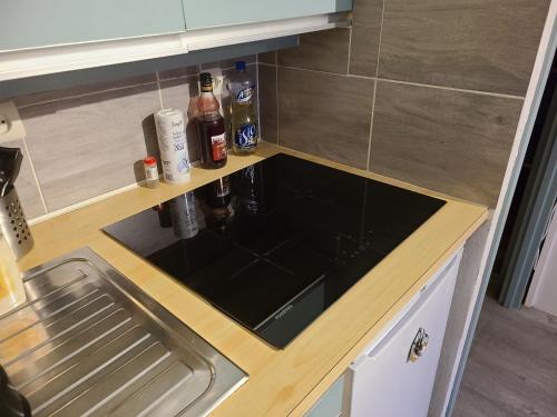 a kitchen counter with a sink and bottles of alcohol at Studio St Lary village-vue montagne. in Saint-Lary-Soulan