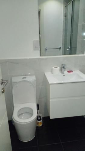 a white bathroom with a toilet and a sink at Embassy garden by Eric in Accra