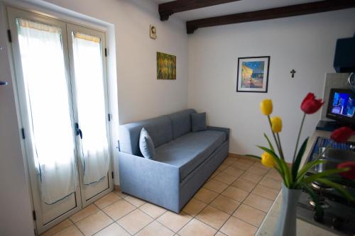 ein Wohnzimmer mit einem Sofa und einer Glasschiebetür in der Unterkunft Sopra La Piazza in Agira