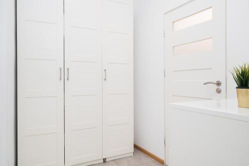 a bathroom with white cabinets and a sink at Harmony Studio by LoftAffair in Krakow