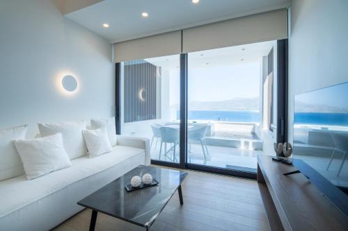 sala de estar con sofá blanco y mesa en GM exclusive Luxury Suites & SPA, en Sitia