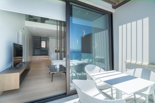 a dining room with a table and chairs on a balcony at GM exclusive Luxury Suites & SPA in Sitia
