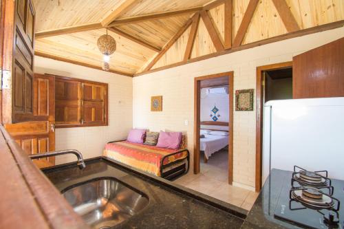 a kitchen with a sink and a bed in a room at Pousada Azul com vistas maravilhosas in Cumuruxatiba