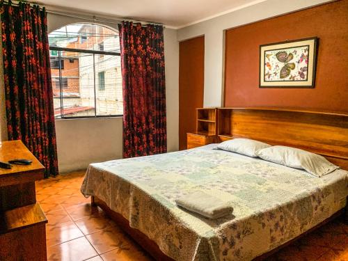 a bedroom with a large bed and a window at CASITA CHANCHAMAYO in La Merced