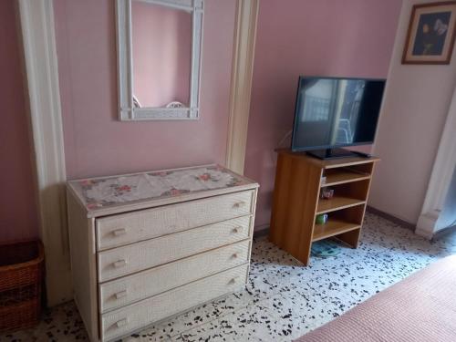 a bedroom with a dresser and a tv and a dresser at Joy's house in Catania