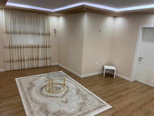 uma sala de estar com uma mesa e um tapete em Vila Qyteza em Korçë