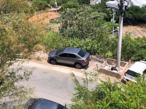a car parked in a parking lot with a person sitting at Cabañas Annapurna in Taganga