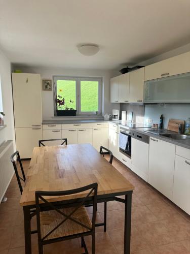 a large kitchen with a wooden table and chairs at Urlaub mit Hund im Salzburger Land in Wegscheid