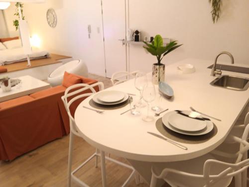a white table with plates and glasses on it in a kitchen at The Luxury White Suite in Charleroi