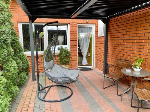 a patio with a swinging chair and a table at Apartament "Tantra Make Love" z fotelem tantrycznym dla Dwojga in Gniezno