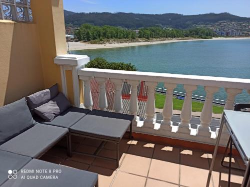 balcón con sofá y vistas al agua en Casa da Costa - Piso con galería y terraza con vistas al mar en Cedeira