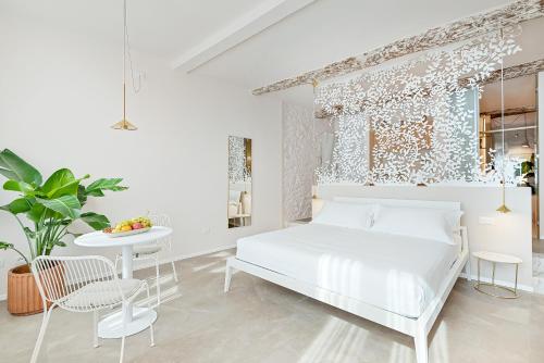 a white bedroom with a bed and a table at La Vista di Marina by The First in Riomaggiore