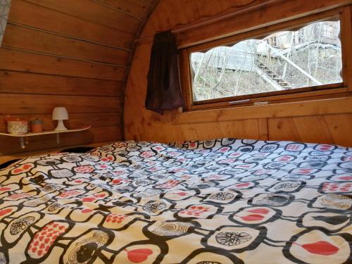 een bed in de hoek van een kamer met een raam bij Appartement Col de la Faucille in Mijoux