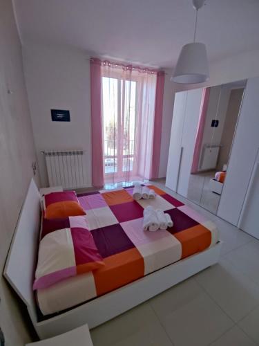 a bedroom with a colorful bed with towels on it at Piazzimmacolata53 in Molfetta