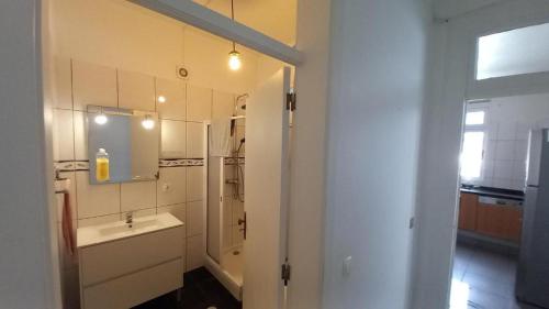 a white bathroom with a sink and a mirror at Shining in Funchal