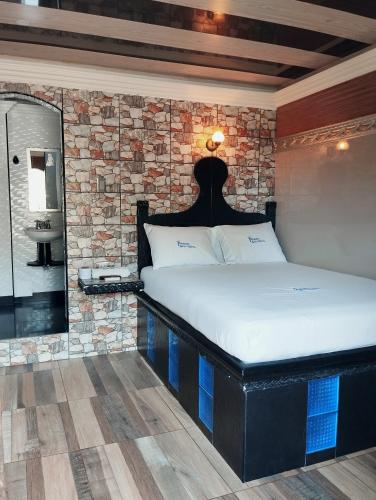 1 dormitorio con cama y pared de piedra en Príncipe azul, en Puerto Colombia