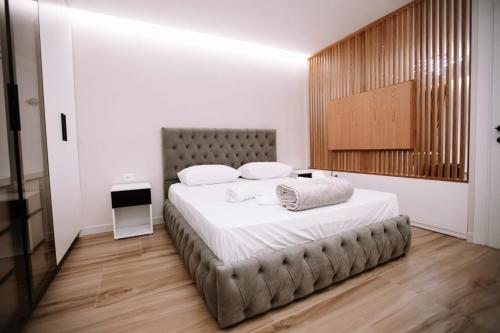 ein Schlafzimmer mit einem großen Bett mit weißer Bettwäsche in der Unterkunft Aljas Luxury Apartment in Tirana