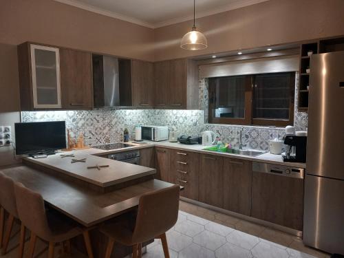 uma cozinha com armários de madeira, uma mesa e um frigorífico em Giannis Villa em Skinés