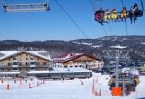 ミジューにあるAppartement Col de la Faucilleの雪の中でスキーリフトに乗っている人々のグループ