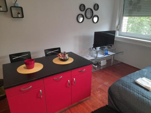 a red cabinet with hats on top of it in a bedroom at Koleos in Osijek