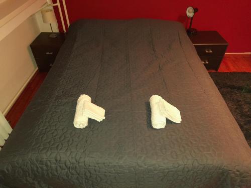 a bed with white slippers on top of it at Koleos in Osijek