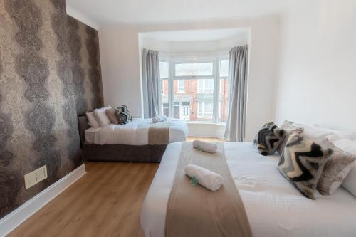 a bedroom with two beds and a window at Malvern - Beautiful 2 bed upper flat Ideal for Contractors Free Parking in South Shields