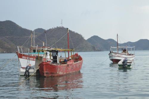 three boats sitting in the water with mountains in the background at Cabañas Annapurna in Taganga