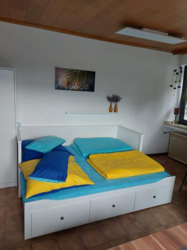 a bedroom with a bed with blue and yellow pillows at Ferienwohnung W.Esel in Wesel