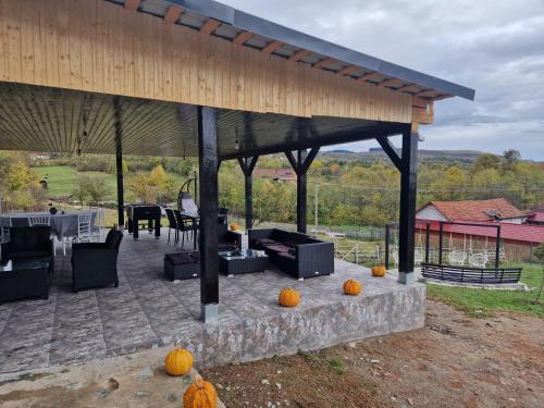a covered patio with pumpkins on the ground at Casa dintre munti in Novaci-Străini