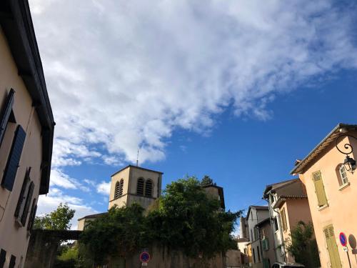 a building with a tower in the middle of a street at La Thibaude - Maison Vigneronne à Charly (proche Lyon) in Charly