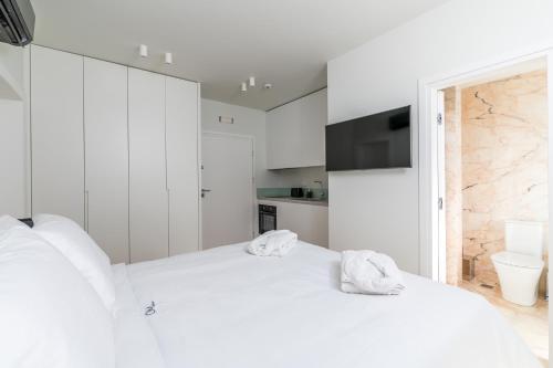 a white bedroom with two towels on a bed at GM exclusive Luxury Suites & SPA in Sitia