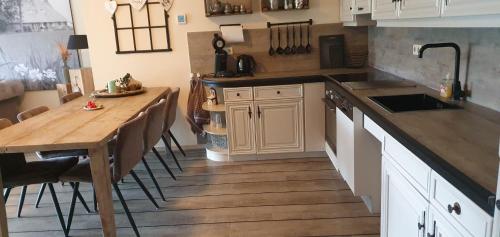 a kitchen with a wooden table and a wooden floor at De Groote Medwert in Holwerd