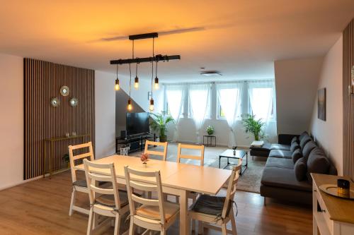 a dining room and living room with a table and chairs at Apartment im Dachgeschoss in Plankstadt