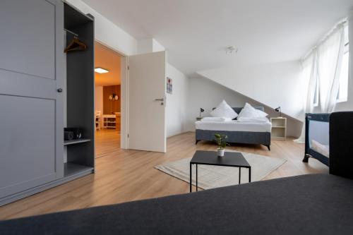 Apartment im Dachgeschoss في Plankstadt: غرفة نوم مع سرير وغرفة معيشة