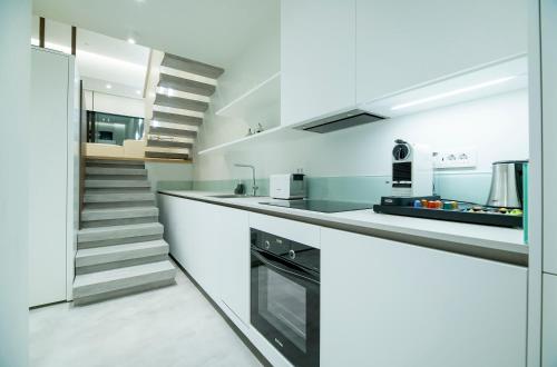 a kitchen with white counters and a staircase at GM exclusive Luxury Suites & SPA in Sitia